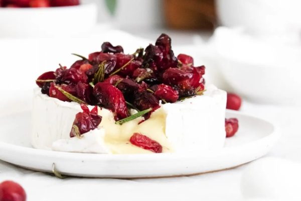 Cranberry brie recipe with cranberries on a white plate.
