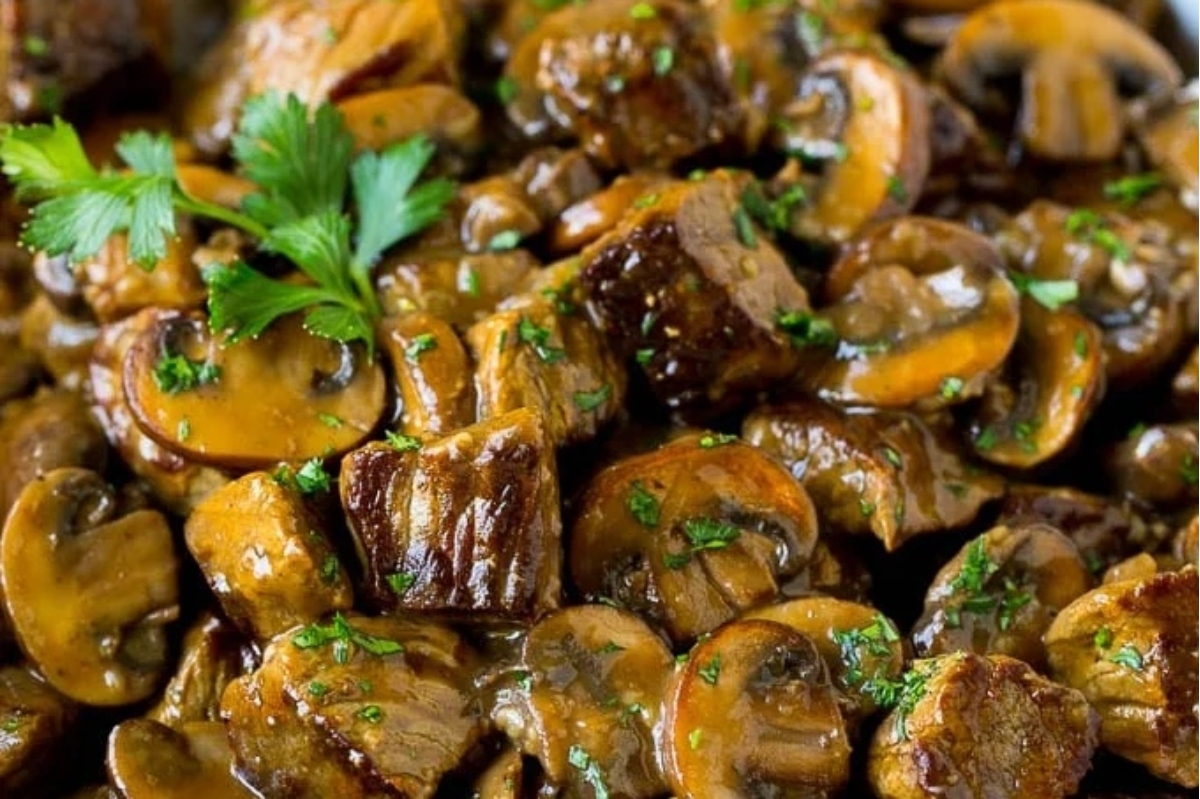 A comforting winter dinner featuring a close up of mushrooms and meat in a sauce.
