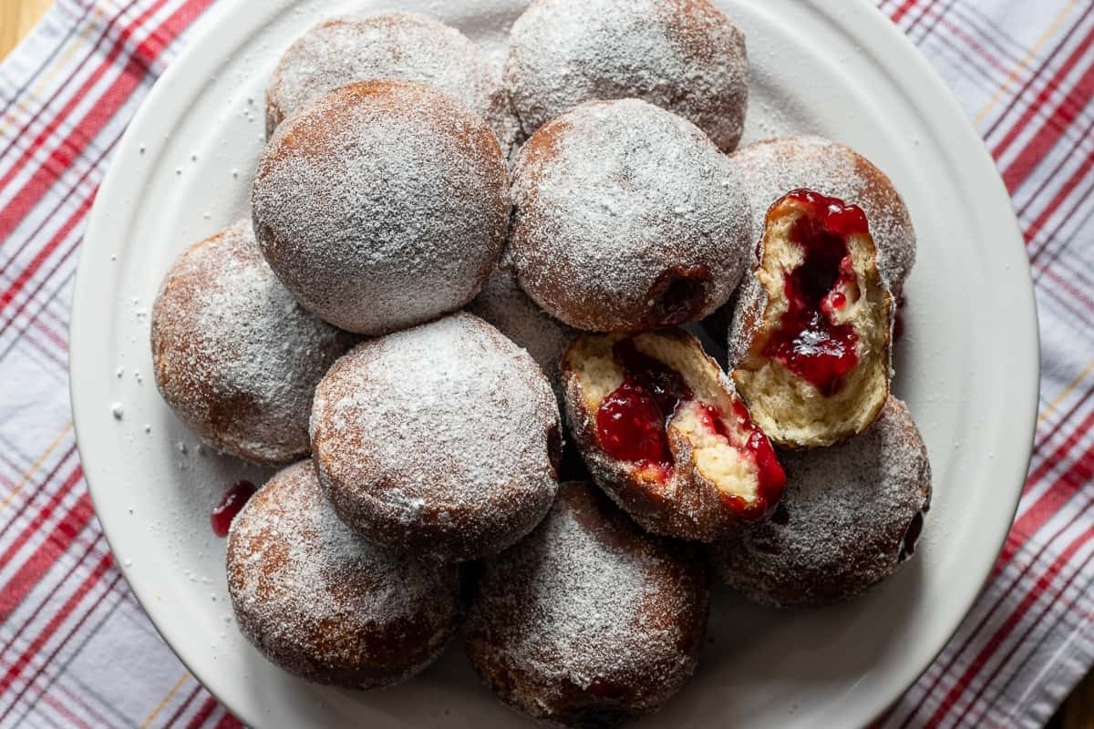 German Recipes - A plate of donuts with jam and powdered sugar, a popular treat in Germany.
