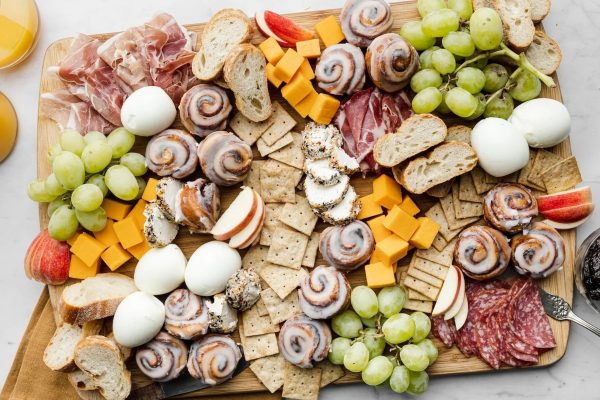 A festive Christmas charcuterie board adorned with a variety of meats and cheeses showcased on a rustic wooden board.