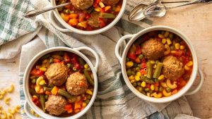 Three bowls of meatballs and Frozen Mixed Vegetables on a table.