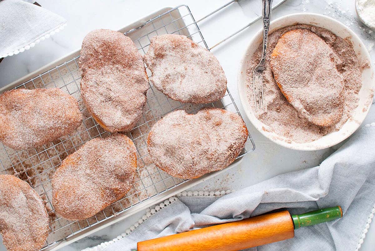 Cinnamon sugar donuts on a cooling rack, perfect for Cinnamon Recipes.