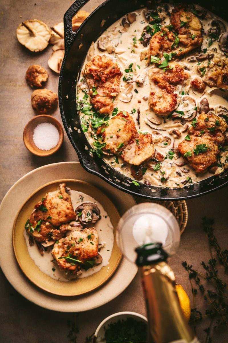 A skillet full of champagne chicken with mushrooms.
