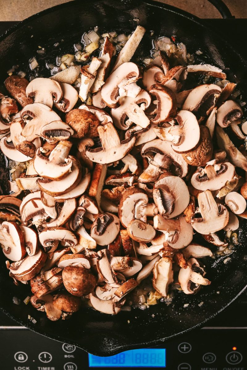Sauteed mushrooms in a skillet on a stove top.