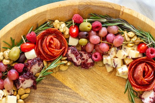 A festive charcuterie board with a variety of fruits and cheeses, perfect for Christmas celebrations.