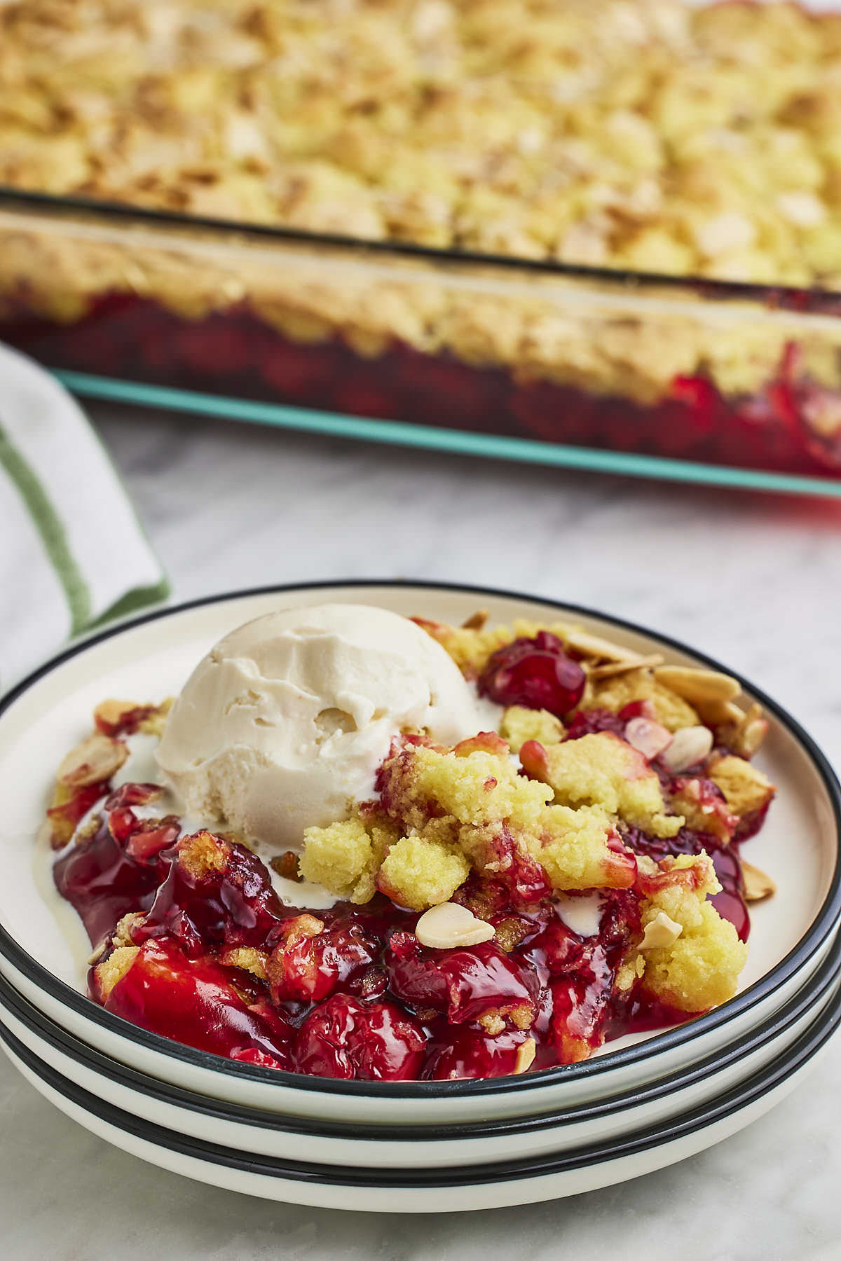 A plate of cranberry crisp with a scoop of ice cream.
