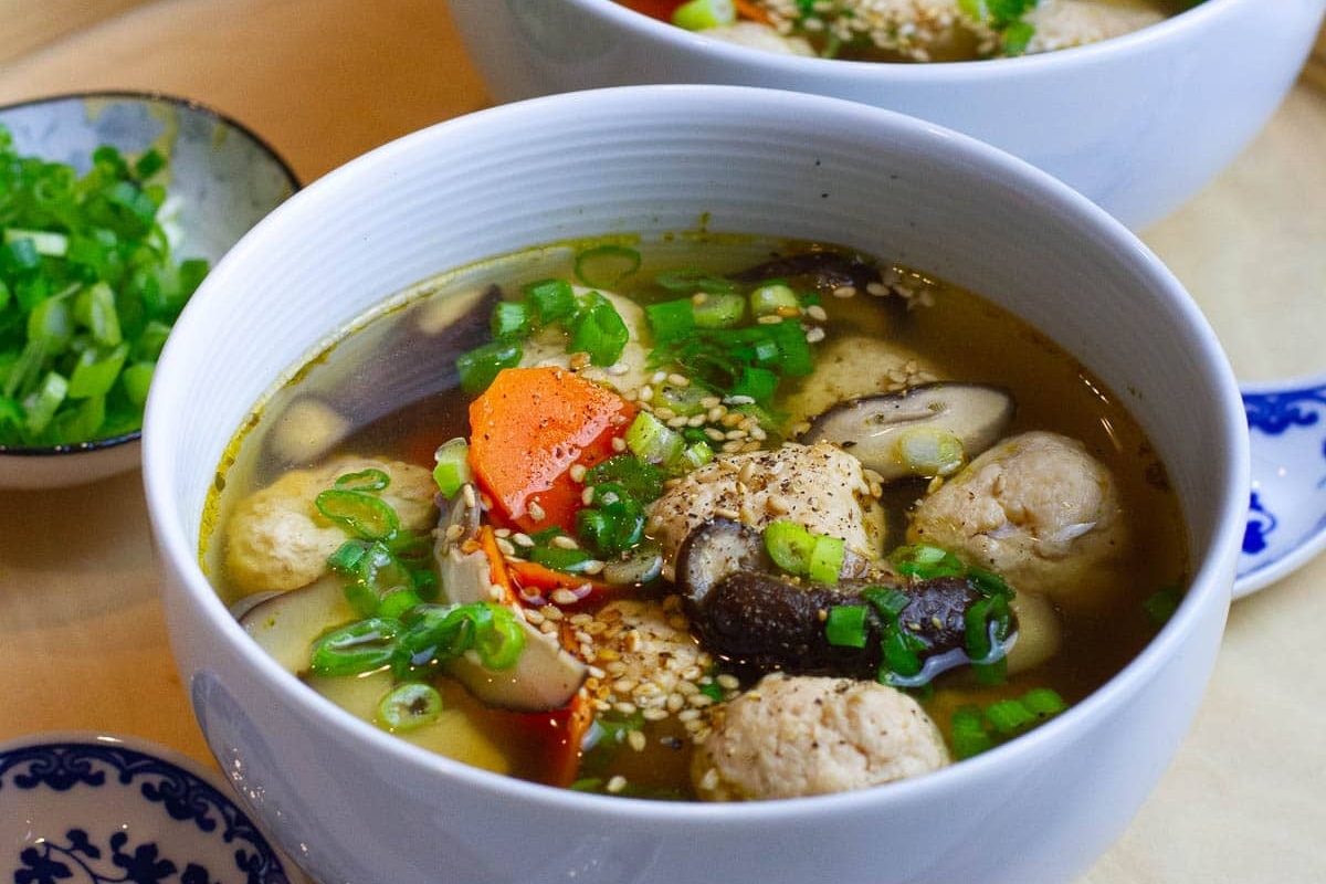 A comforting bowl of winter soup with delicious meatballs and nutritious vegetables.