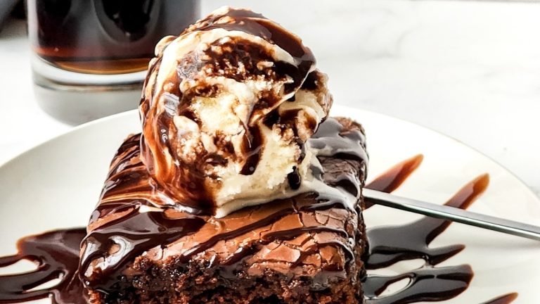 A slice of chocolate cake with ice cream and a scoop of ice cream.