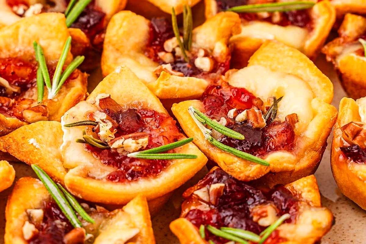 These festive cranberry cheesecake bites with rosemary sprigs are perfect for your Christmas party appetizers.