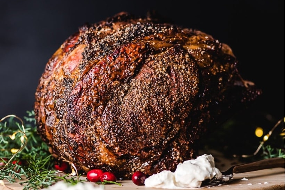 A Thanksgiving main, a roasted prime rib sits on a cutting board.