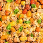 A sheet pan pizza with tomatoes and basil on it.