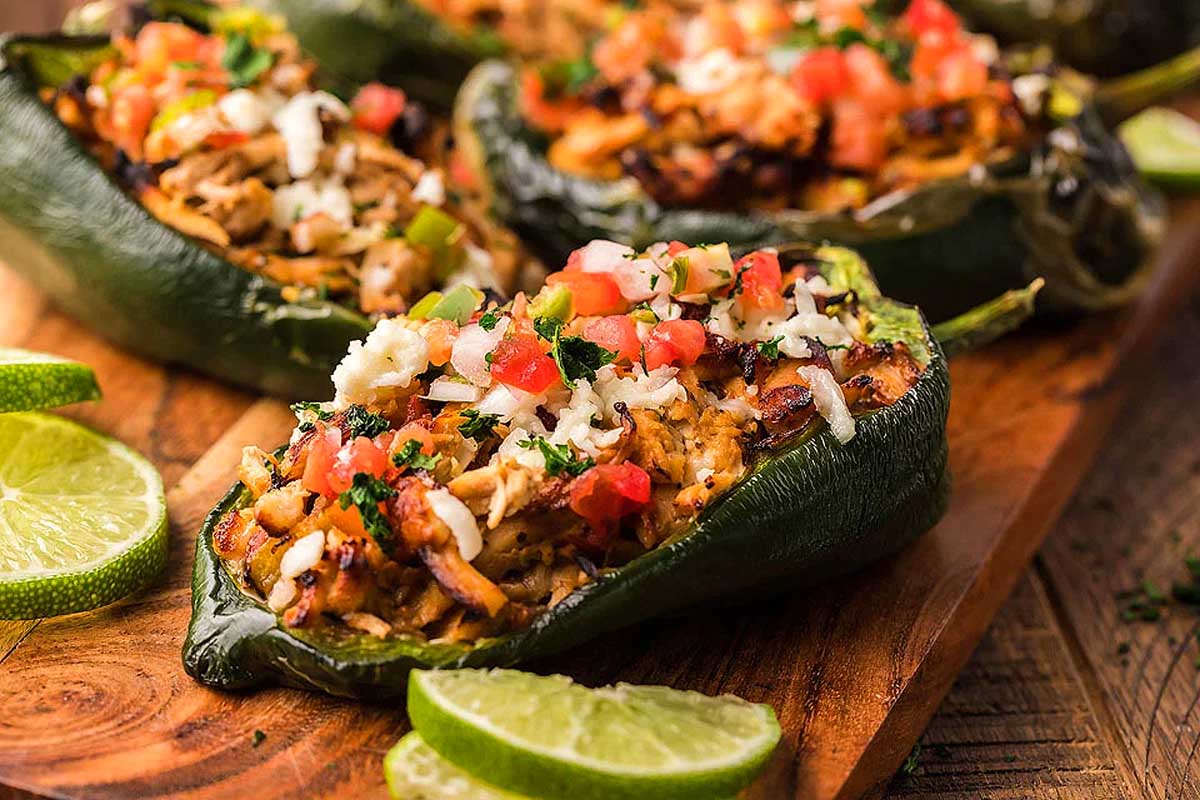 Mexican stuffed peppers on a wooden cutting board.
