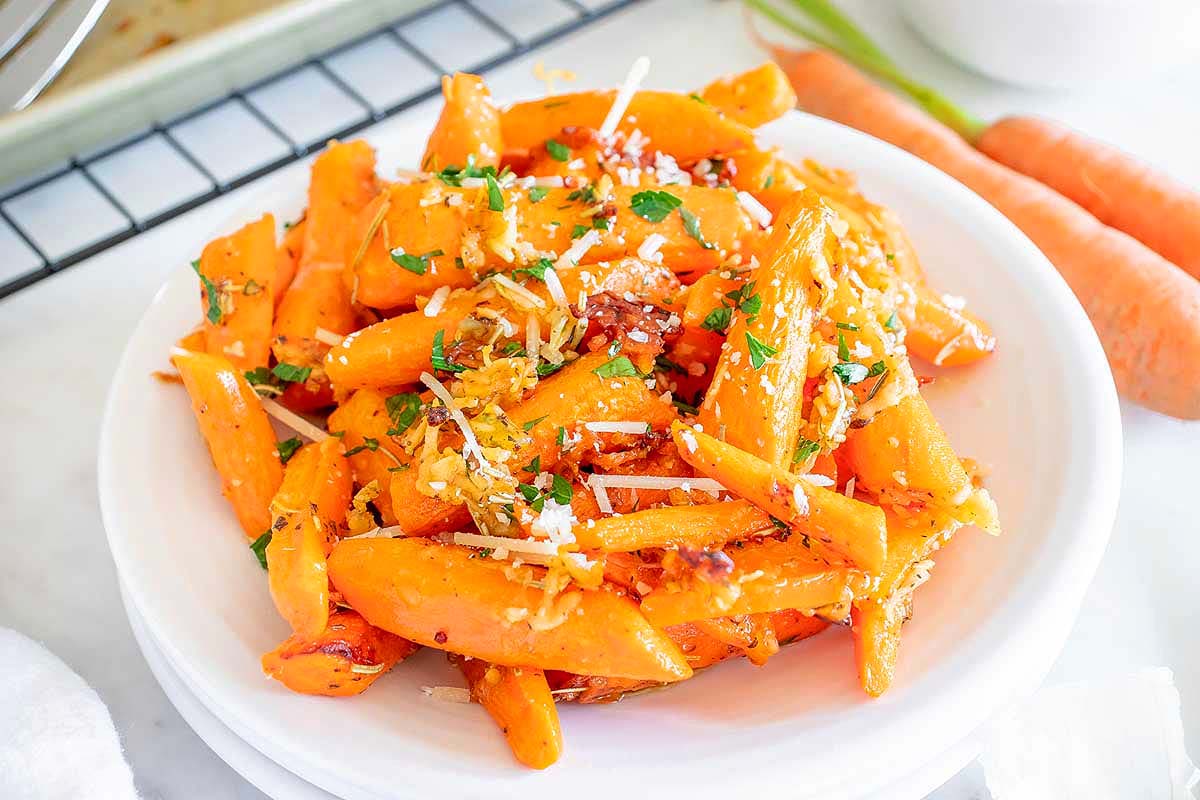 Carrots in a white bowl with parmesan cheese, perfect as a side dish for turkey.