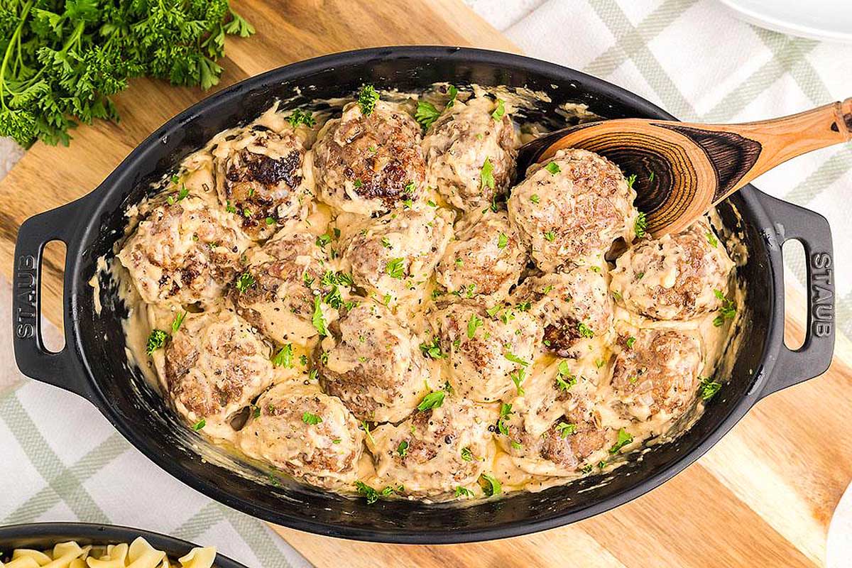 A skillet filled with meatballs and pasta.
