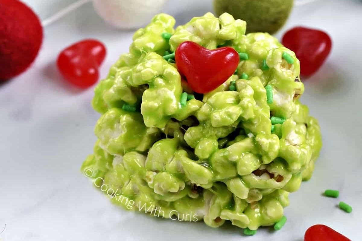 A green popcorn tree with a red heart on top, perfect for a Grinch-themed party or as a festive centerpiece for your holiday recipes.