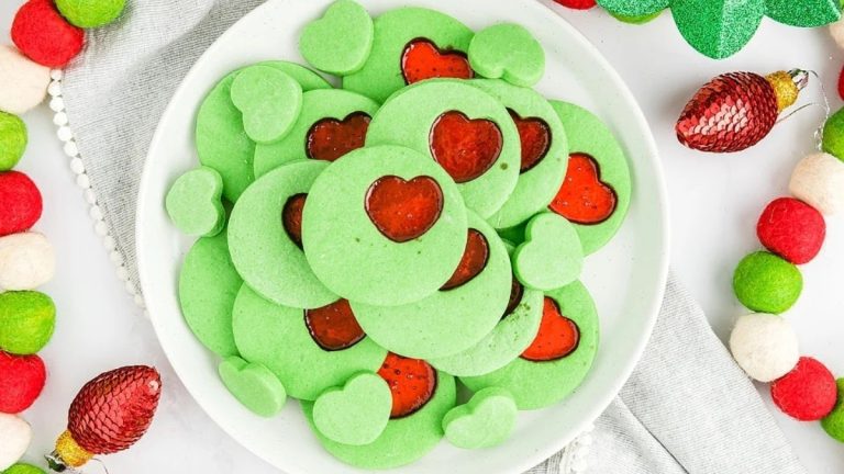A plate of green cookies with hearts on it, perfect for Grinch-themed recipes.