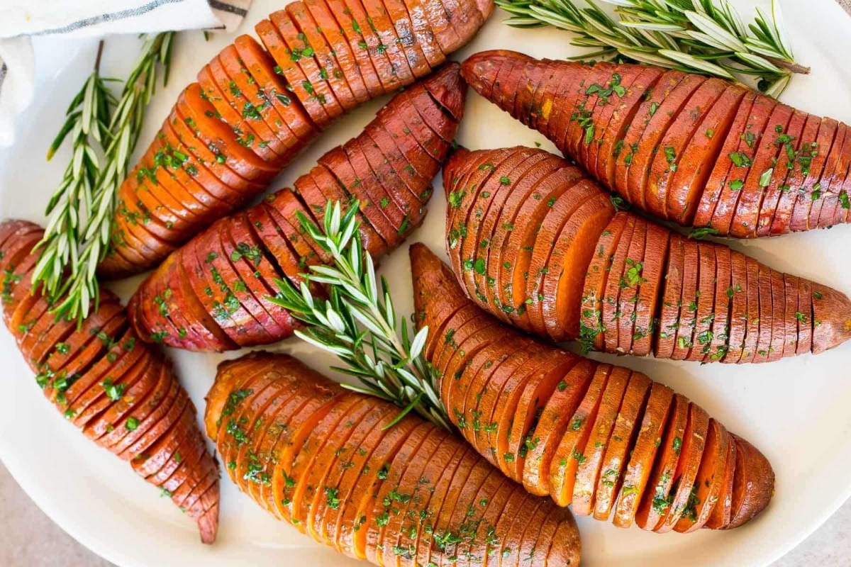 Thanksgiving sheet pan recipe featuring roasted sweet potatoes with rosemary sprigs.