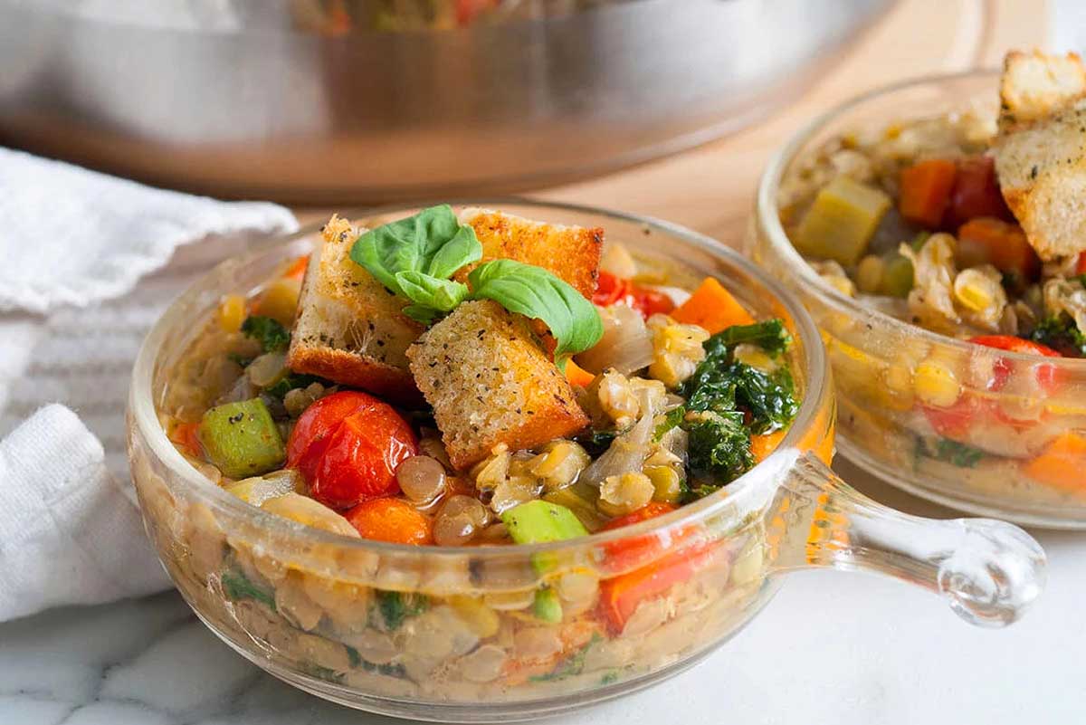 Two bowls of vegetables and croutons in front of an instant pot. This is one of the best Italian soup recipes.