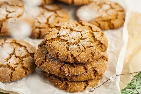 A stack of ginger cookies on a piece of paper, perfect for Holiday Recipes and enjoying with a cup of Starbucks coffee.