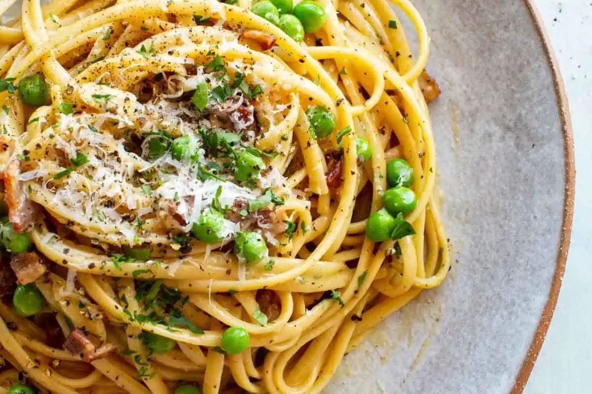 A plate of pasta with frozen peas and bacon recipe.