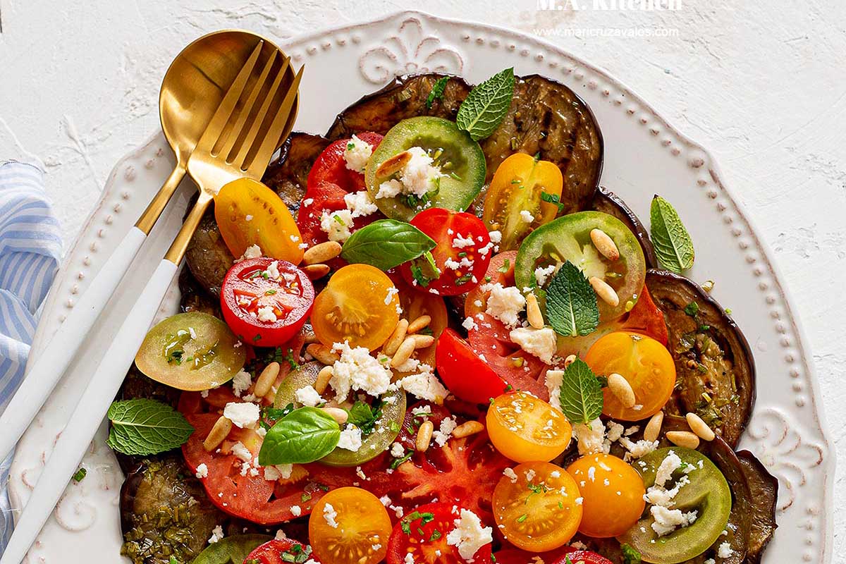 A plate with tomatoes, cucumbers and feta on it.