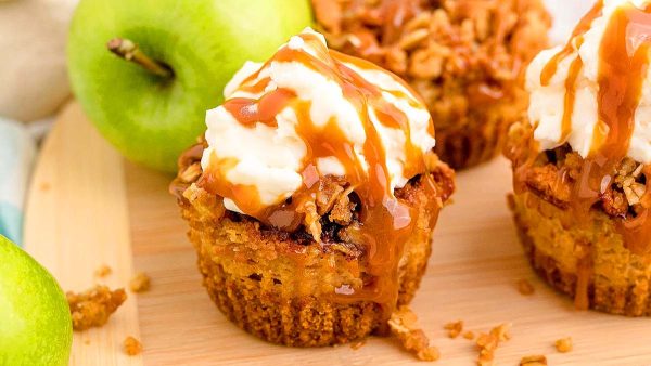 Three apple cupcakes topped with whipped cream and caramel sauce, perfect for apple lovers. This is one of the best caramel recipes.