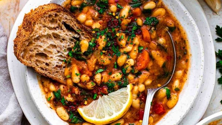 A comforting bowl of white bean soup, perfect for the winter season. Served with a side of warm bread.