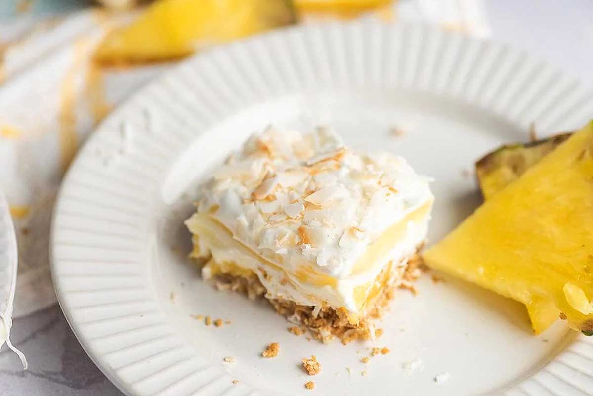 A luau-inspired slice of pineapple cake on a white plate.