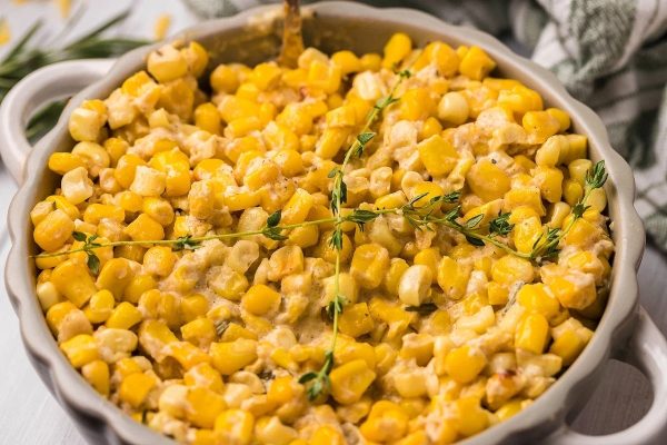 An appetizing corn on the cob in a white dish, perfect for Thanksgiving or a potluck gathering.