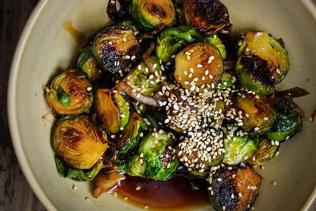 Brussels sprouts in a bowl with sesame seeds.