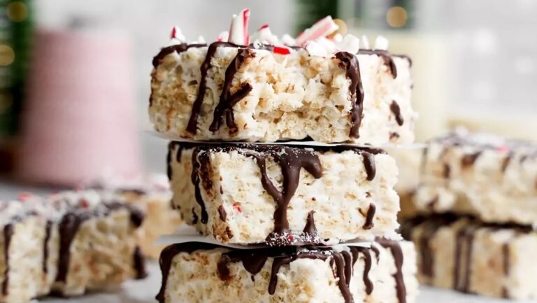 A stack of rice krispy treats with chocolate and peppermint drizzle.