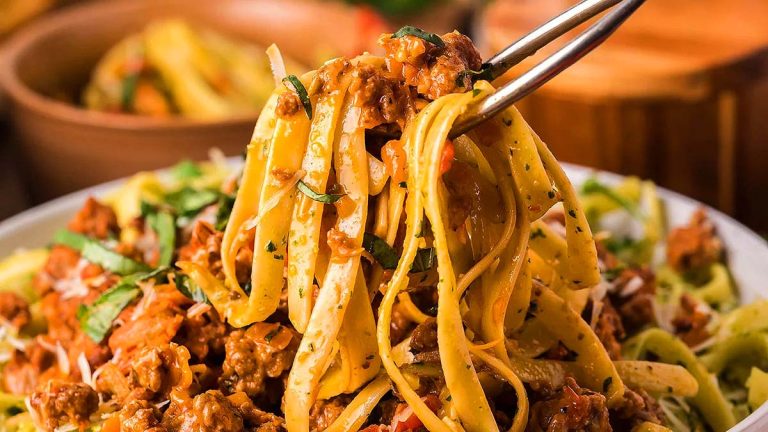 Pasta being scooped form a bowl.