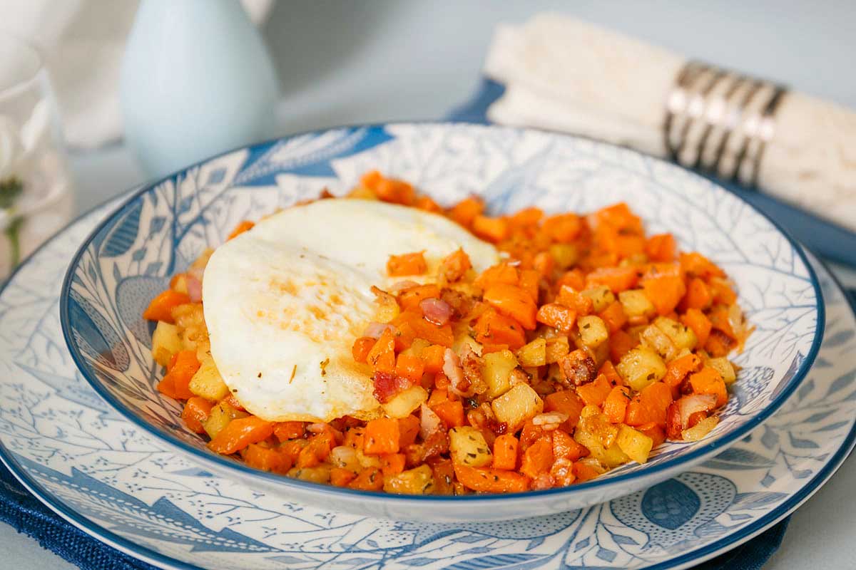 A bowl with a fried egg and carrots.