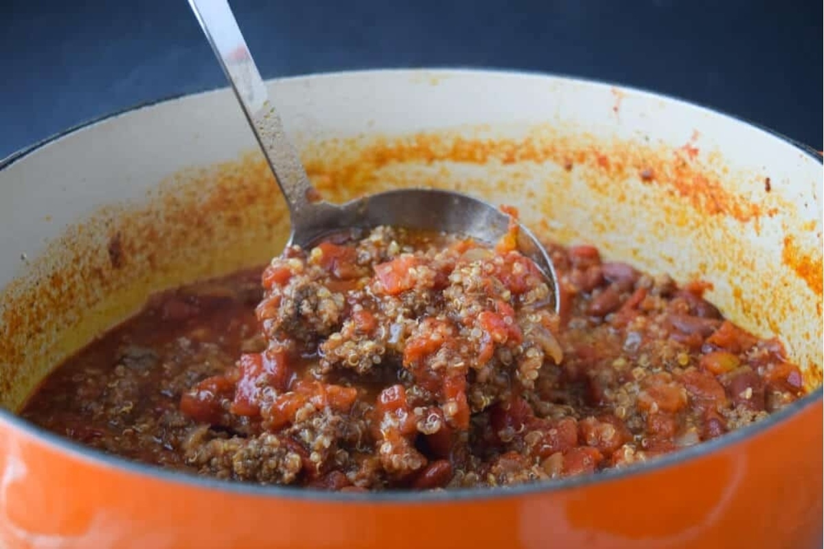A comforting spoonful of winter chili in an orange pot.