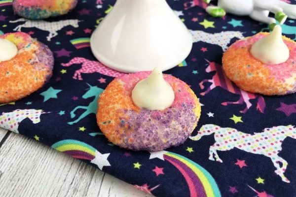 Unicorn cookies with sprinkles on a tablecloth.