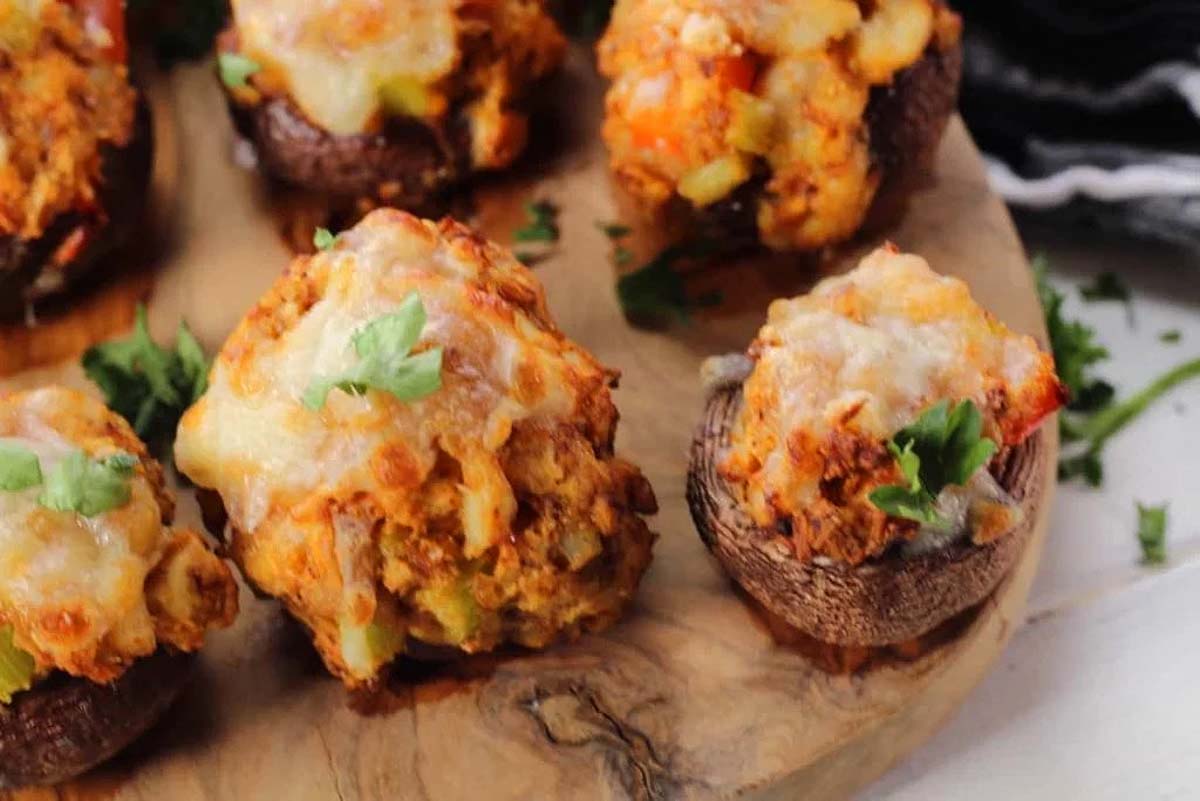 Mouthwatering stuffed mushrooms on a rustic wooden cutting board perfect for any occasion.