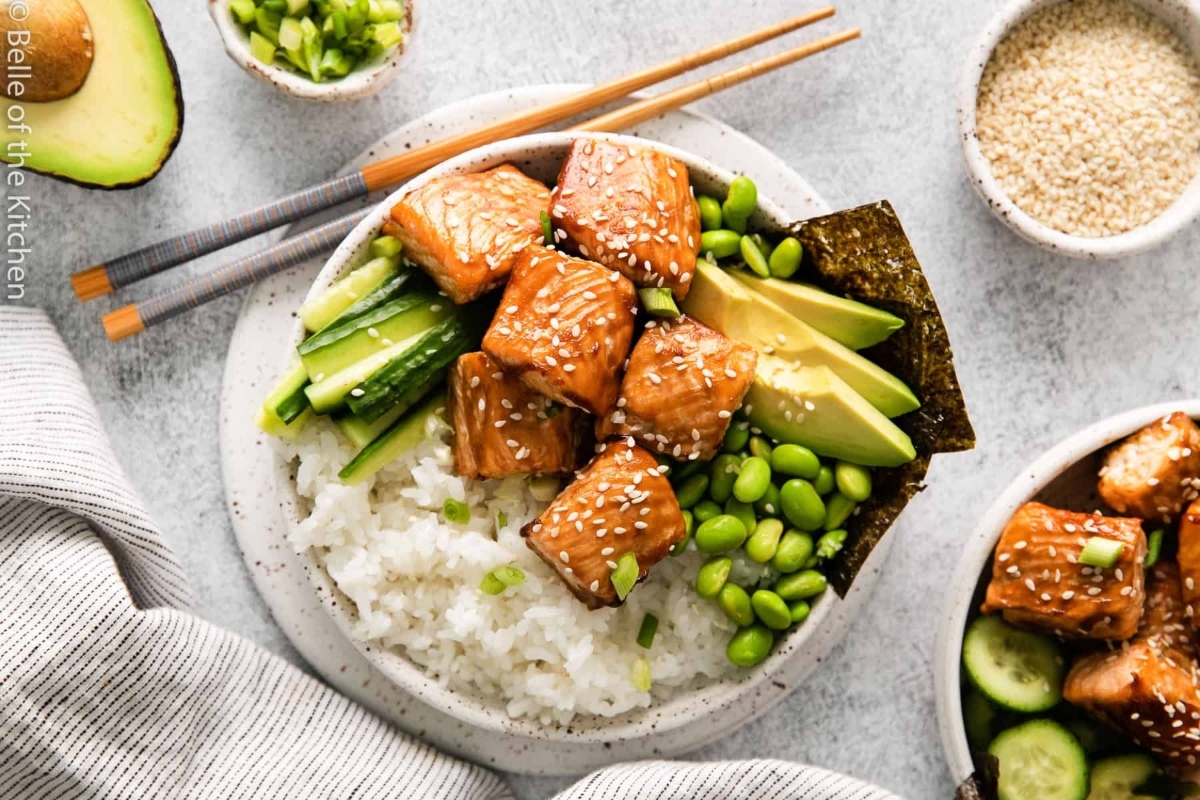 Salmon Dinner: A bowl of asian food with salmon, cucumber and avocado.