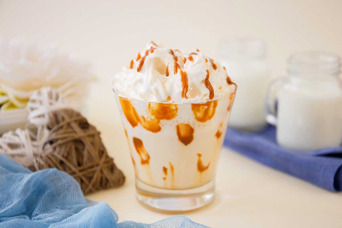 A milkshake with whipped cream and caramel sauce.