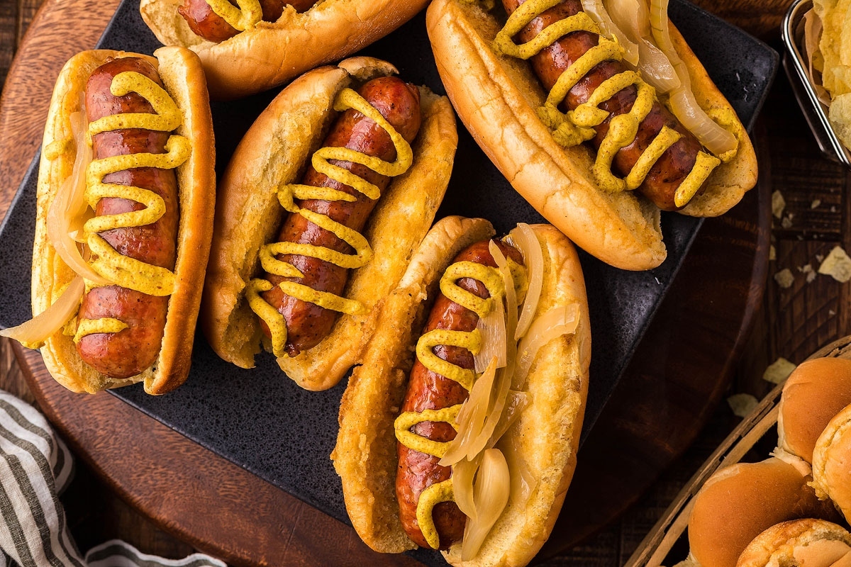 Traditional German hot dogs with mustard and onions on a plate.