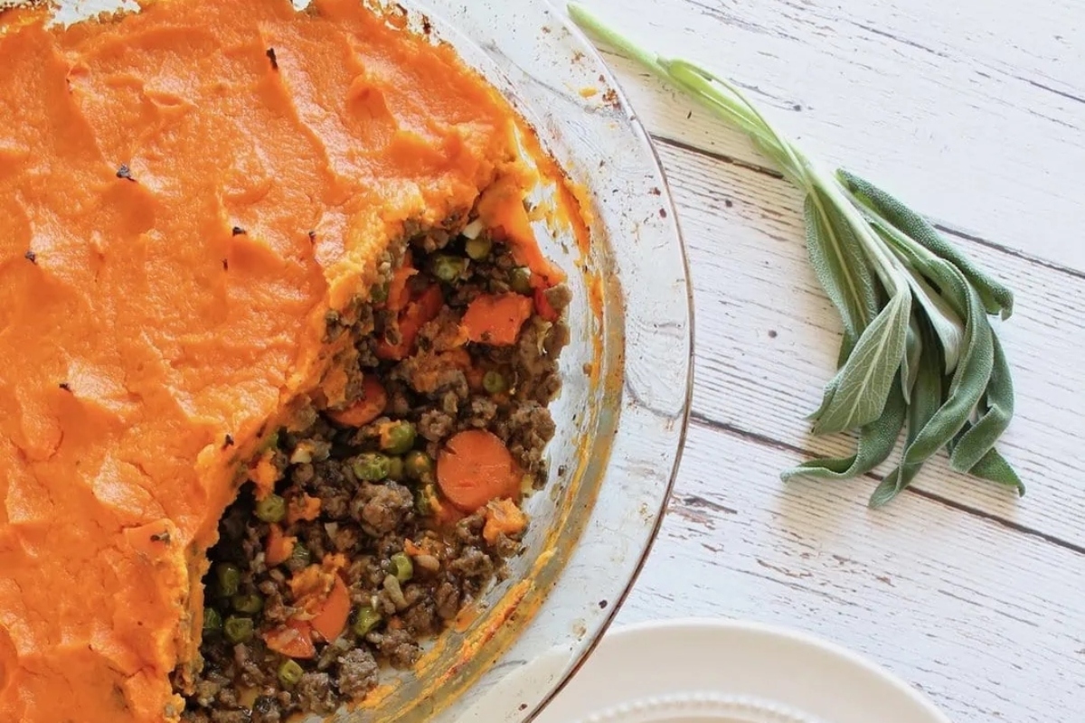 A pie with carrots, lentils, frozen peas, and sprigs of sage.