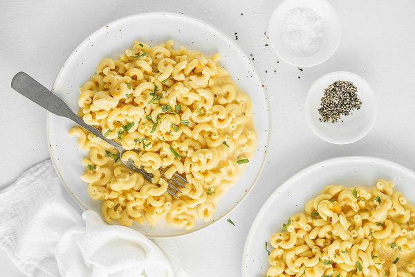 Two plates of macaroni and cheese on a white background, perfect for an Instant Pot Thanksgiving feast.