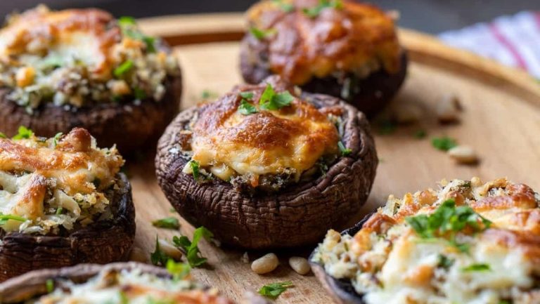New Year's Eve appetizers, stuffed mushrooms with cheese and parsley on a wooden board.