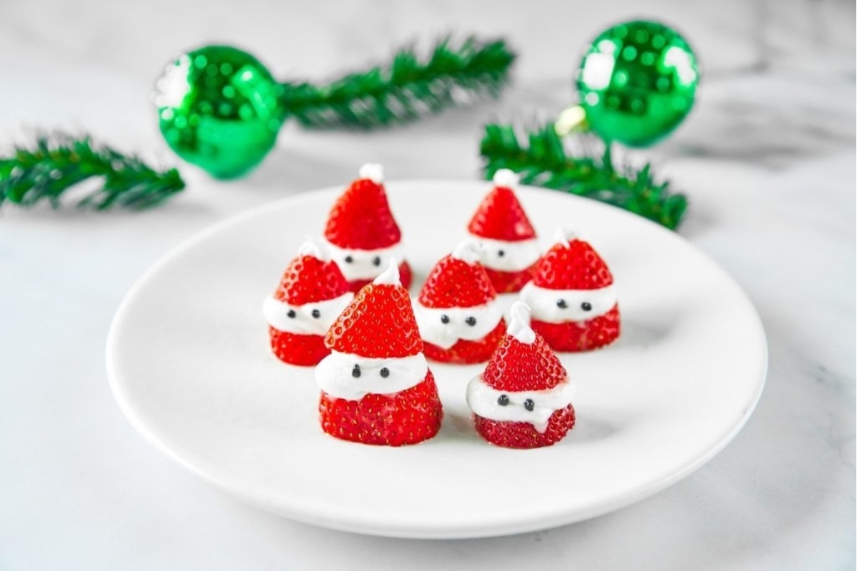 Themed Santa strawberries on a white plate.