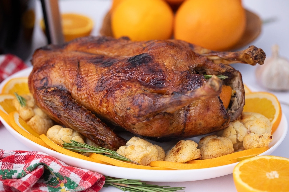 A Simple and Elegant roasted turkey with oranges and garlic on a plate, perfect for New Year's Eve.