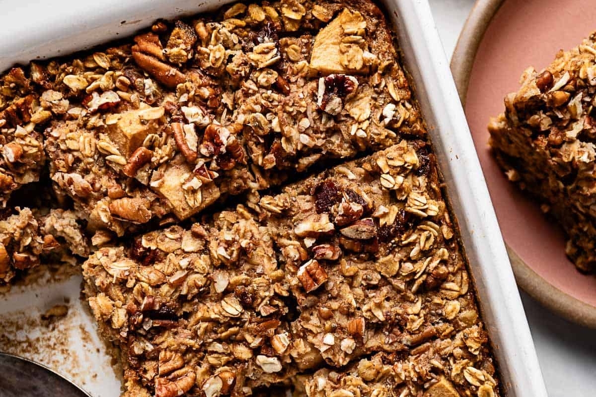 Sweet granola bars in a white dish with a spoon.