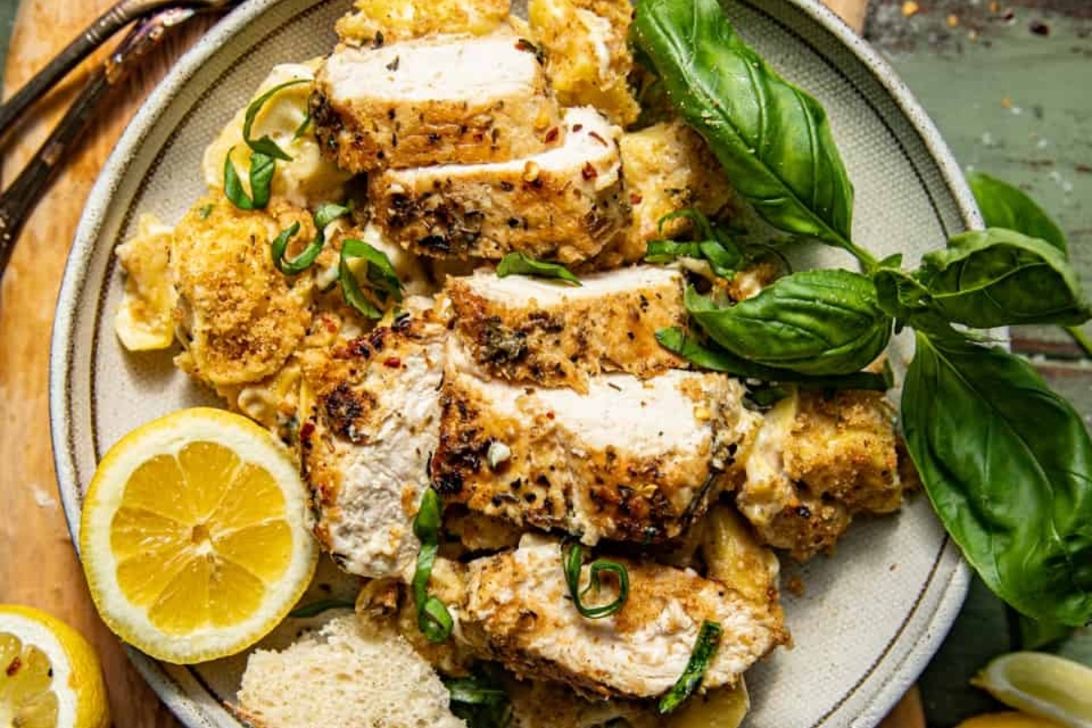 Grilled chicken with lemon and herbs on a plate.