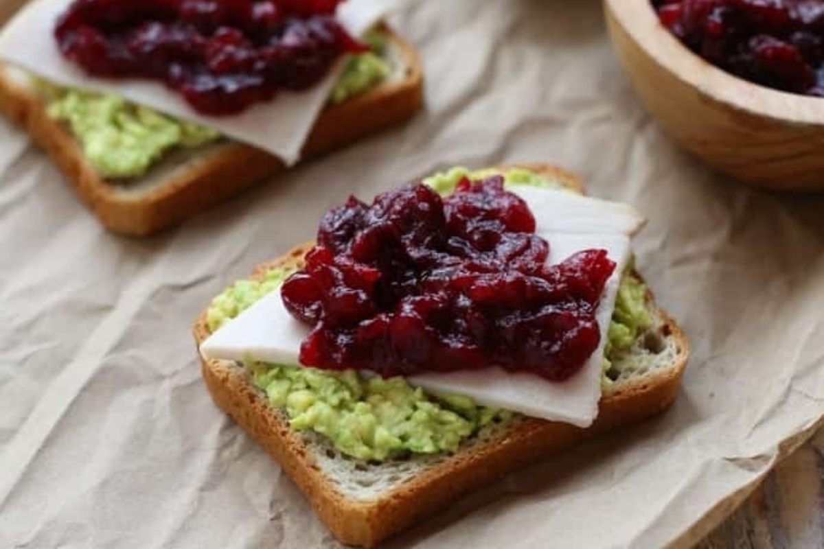 A cranberry snack made with two slices of bread and cranberry sauce.
