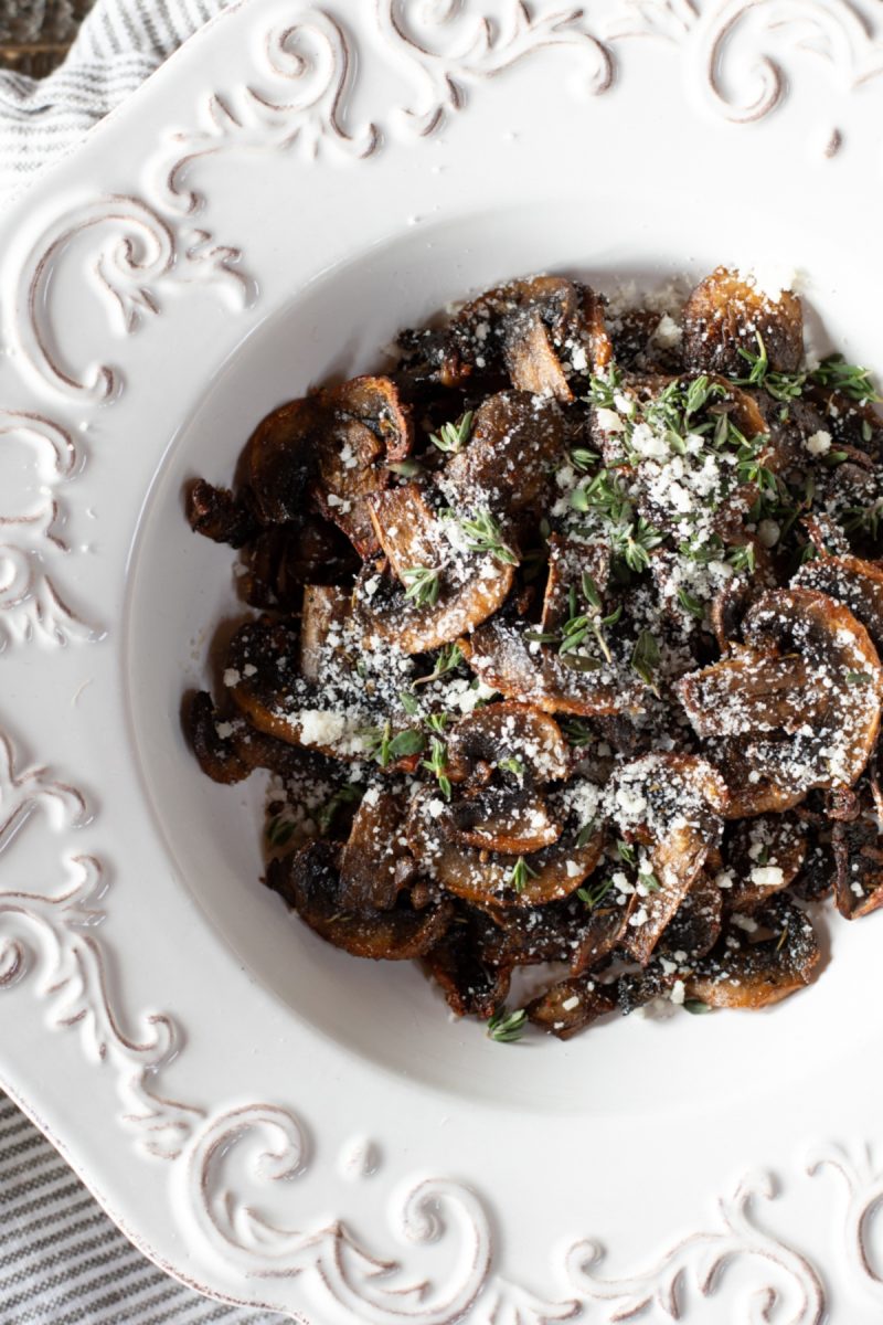A plate with air fryer mushrooms and parmesan on it.