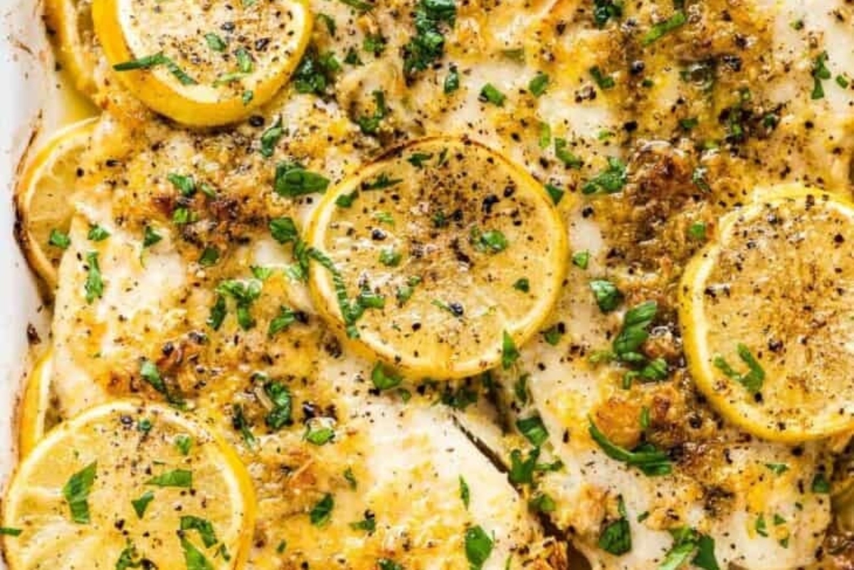 A fish baking dish with lemons and herbs on it, perfect for delicious recipes.