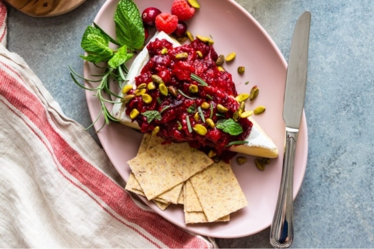 Cranberry and pistachio cheese with crackers, a delicious snack featuring cranberry and pistachios.
